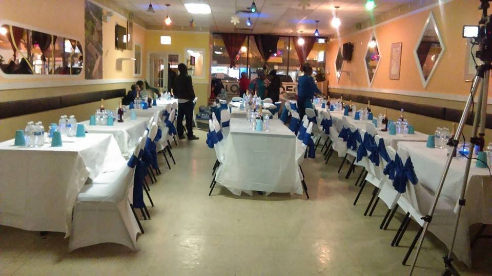 tables set for party with blue ribbons around backs of chairs